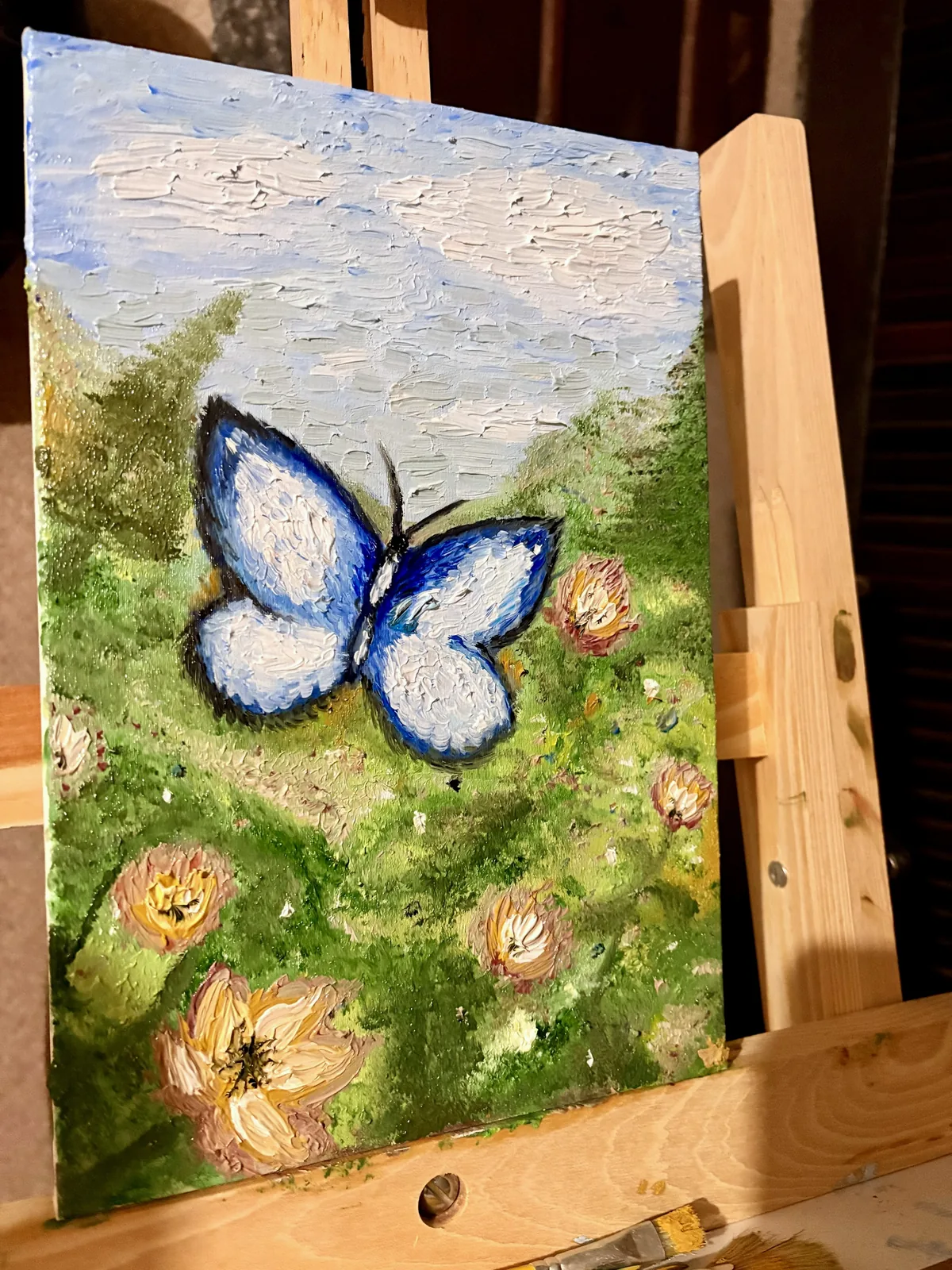 A pintura Borboleta Azul em um cavalete de madeira.