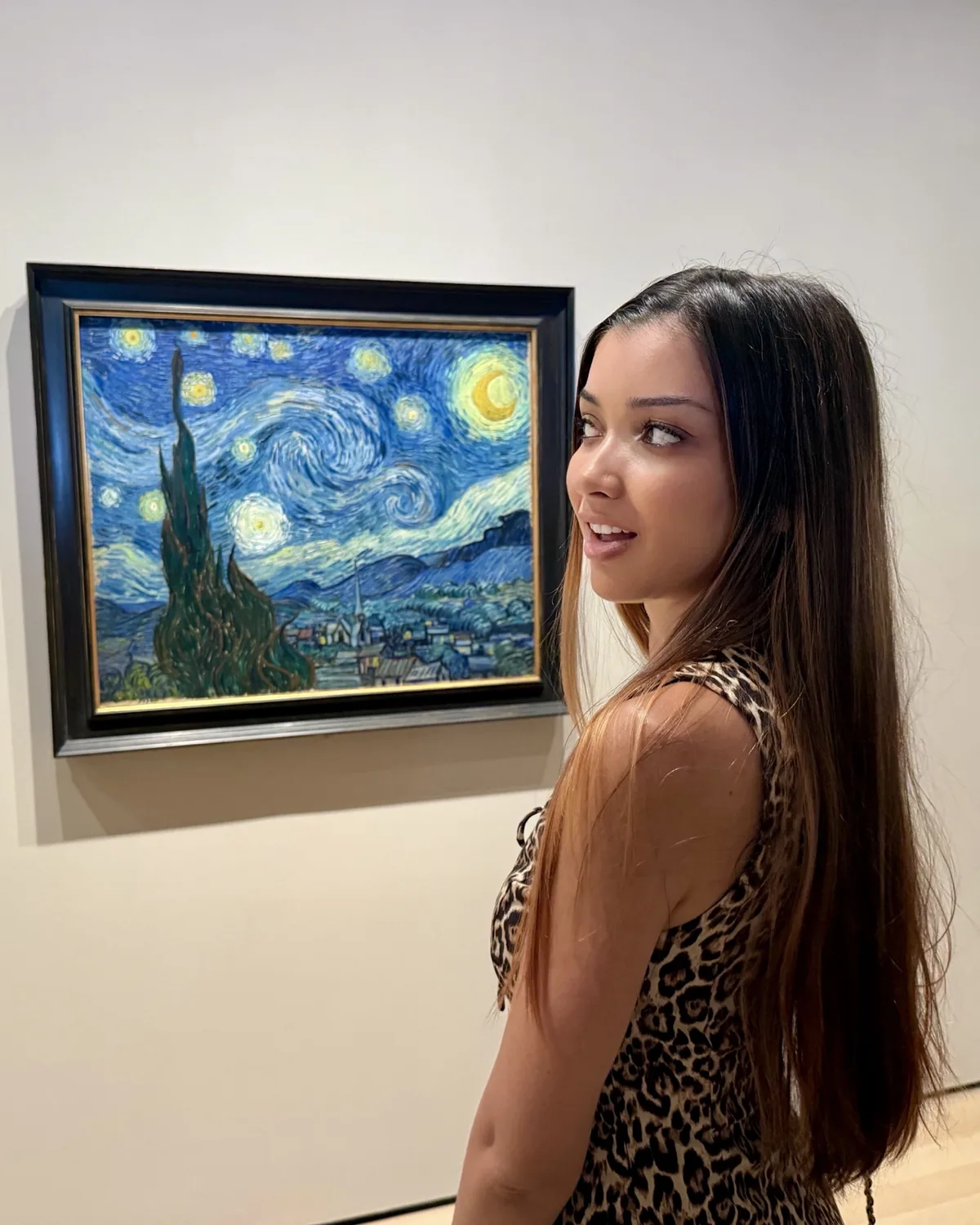 Ana Carolina olhando para trás, ao lado de A noite estrelada, de Vincent van Gogh.