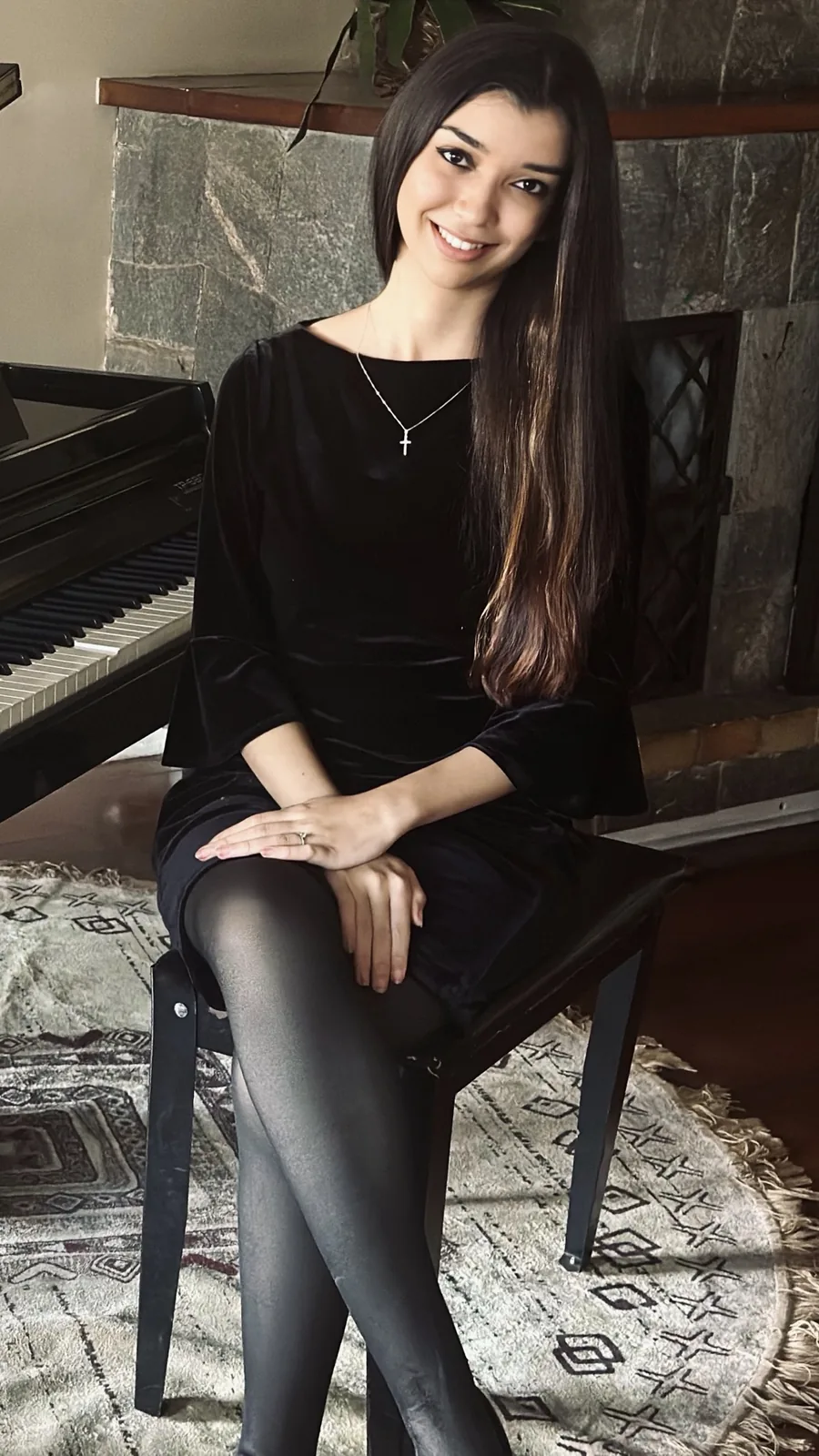 Ana Carolina sentada ao lado de um piano de cauda.